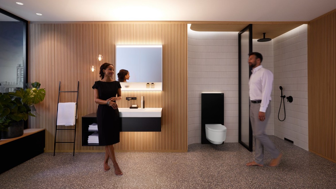 Чоловік і жінка в ідеально освітленій ванній кімнаті з виробами Geberit ONE