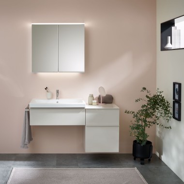 Меблі для ванної кімнати, умивальник і дзеркальна шафа від Geberit перед пастельною стіною